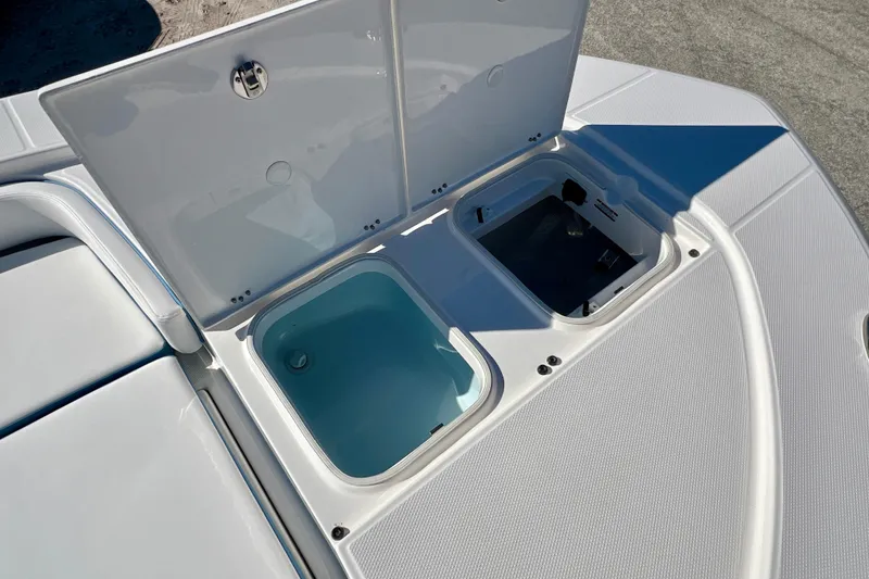 Slide: The Image of Open storage compartments on 2026 Robalo 246 Cayman boat deck. - 27