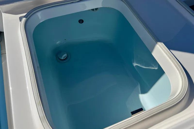 Slide: The Image of Livewell compartment on a 2026 Robalo 246 Cayman boat, featuring a clean, blue interior. - 28