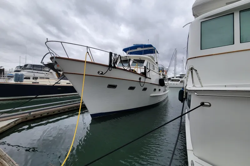 Slide: The Image of 2001 DeFever Pilothouse yacht docked at marina under cloudy skies. - 1