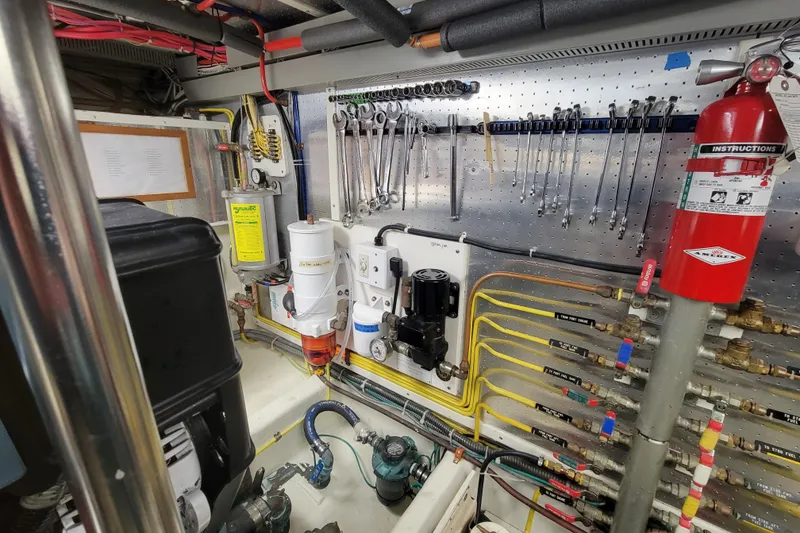Slide: The Image of Engine room of 2001 DeFever Pilothouse with tools, fire extinguisher, and hydraulic system. - 12