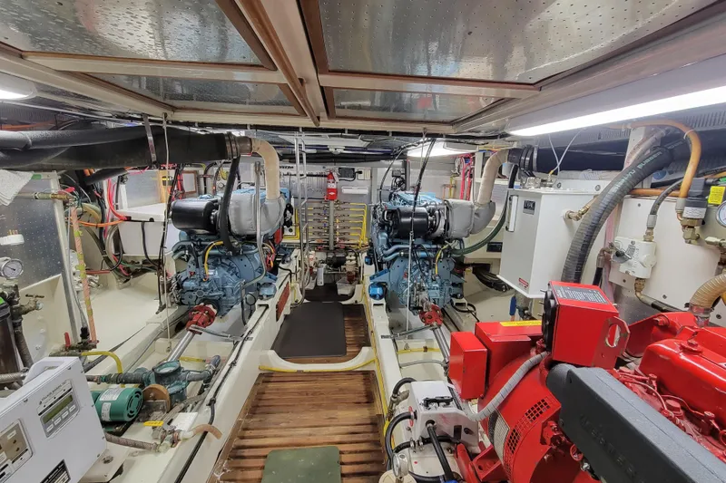 Slide: The Image of Engine room of a 2001 DeFever Pilothouse yacht, showcasing dual engines and equipment. - 16