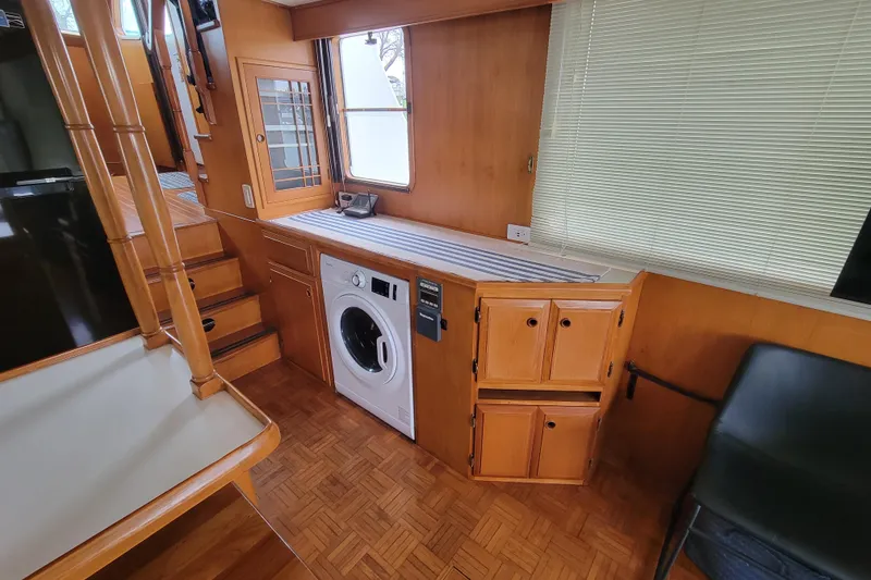 Slide: The Image of Interior of 2001 DeFever Pilothouse with washer, wooden cabinets, and stairs. - 21