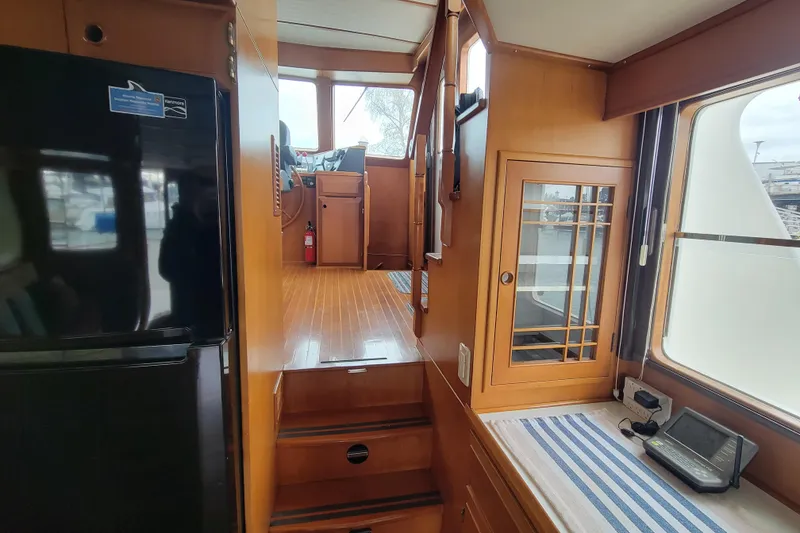 Slide: The Image of Interior view of 2001 DeFever Pilothouse yacht, featuring wooden cabinetry and pilothouse access. - 24
