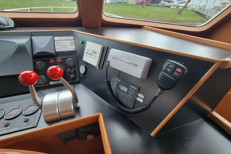 Slide: The Image of Pilothouse controls of a 2001 DeFever boat with communication equipment and throttle levers. - 28