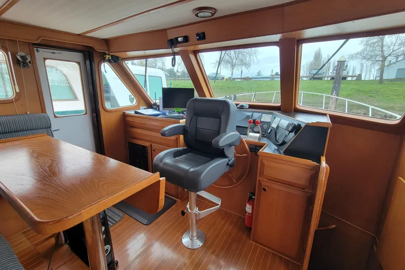 Slide: The Image of 2001 DeFever Pilothouse interior with helm, captain's chair, and wooden furnishings. - 29