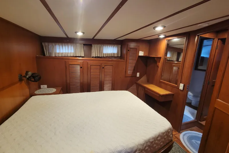 Slide: The Image of Luxurious 2001 DeFever Pilothouse bedroom with wood paneling and ensuite bathroom. - 32