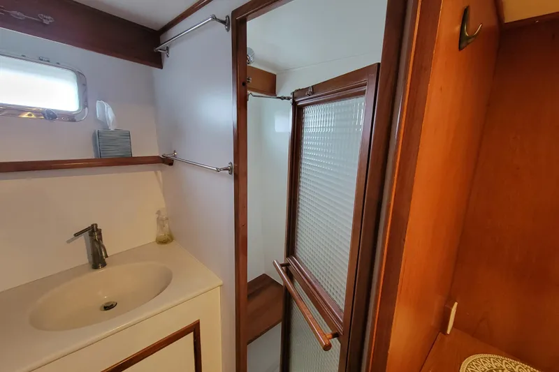 Slide: The Image of 2001 DeFever Pilothouse bathroom with sink, shower, and wooden accents. - 33