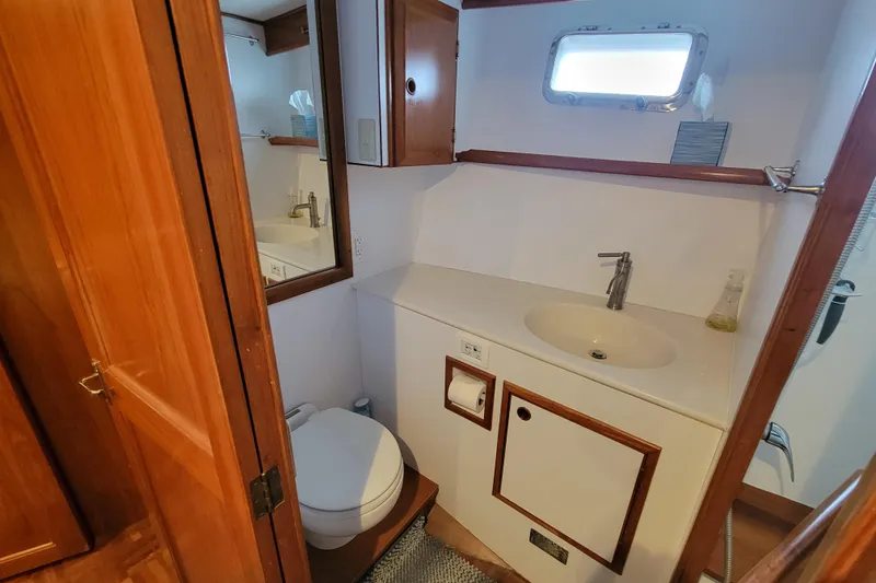 Slide: The Image of 2001 DeFever Pilothouse bathroom with wooden cabinetry, sink, and toilet. - 34
