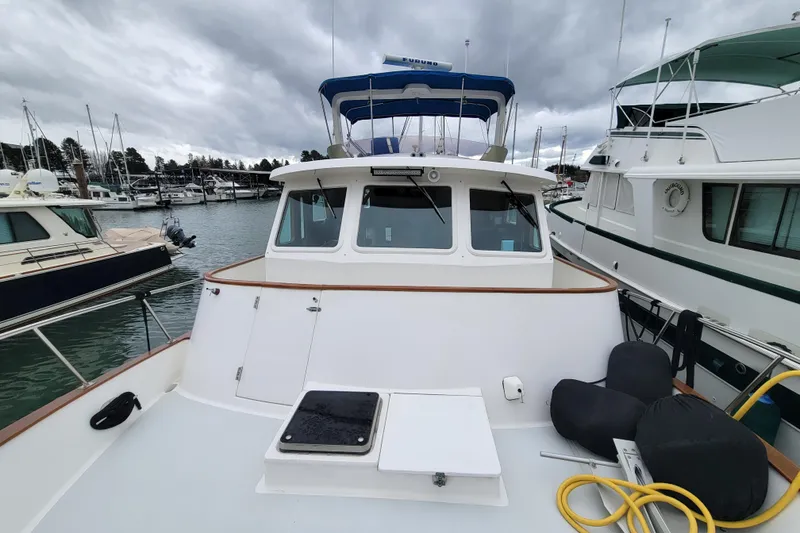 Slide: The Image of 2001 DeFever Pilothouse boat docked at marina under cloudy skies. - 6