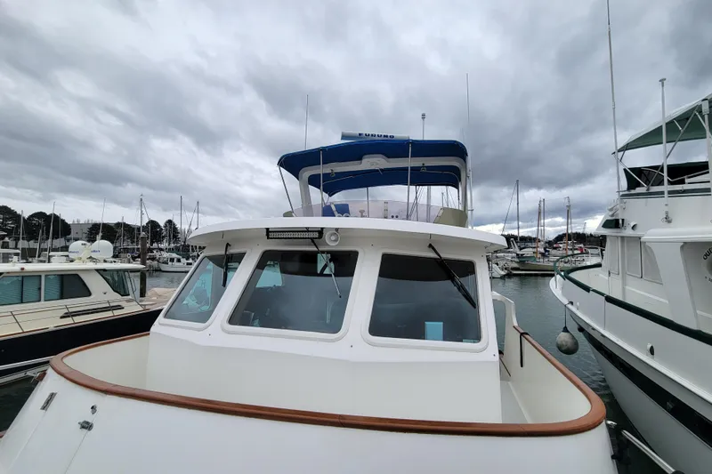 Slide: The Image of 2001 DeFever Pilothouse boat docked in a marina under cloudy skies. - 9