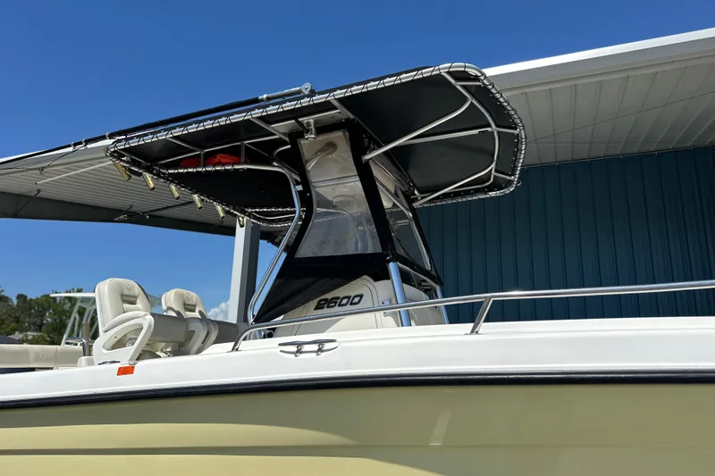 Slide: The Image of 2007 Century 2600 Center Console boat with T-top and seating, docked under a canopy. - 2