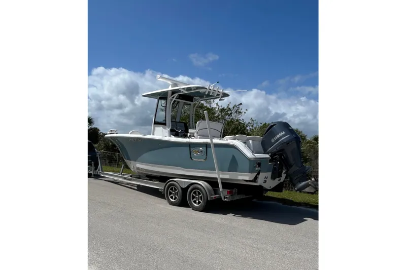 The Image of 2021 Sea Hunt Ultra 255 SE boat on trailer, parked outdoors under a blue sky. - 0