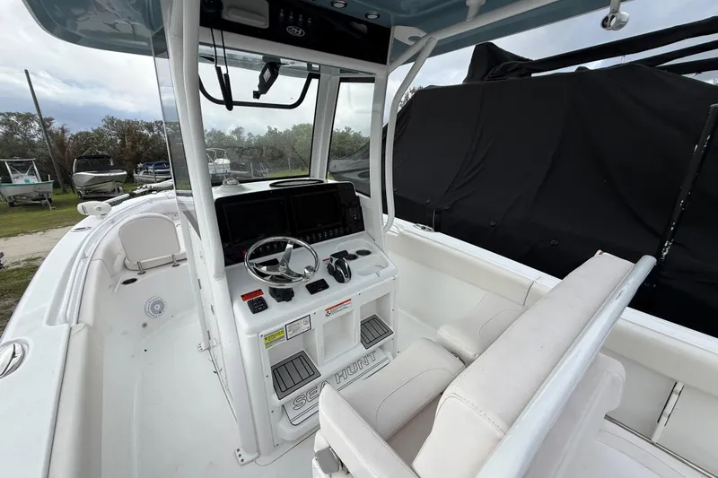 Slide: The Image of 2021 Sea Hunt Ultra 255 SE boat interior with steering console and seating. - 12