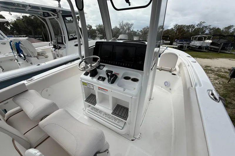 Slide: The Image of 2021 Sea Hunt Ultra 255 SE boat interior with steering console and seating. - 13