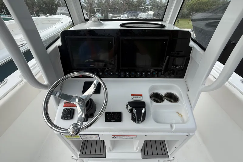 Slide: The Image of 2021 Sea Hunt Ultra 255 SE boat console with steering wheel, dual displays, and controls. - 15