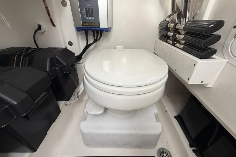 Slide: The Image of Marine toilet in 2021 Sea Hunt Ultra 255 SE boat cabin, with storage compartments. - 18
