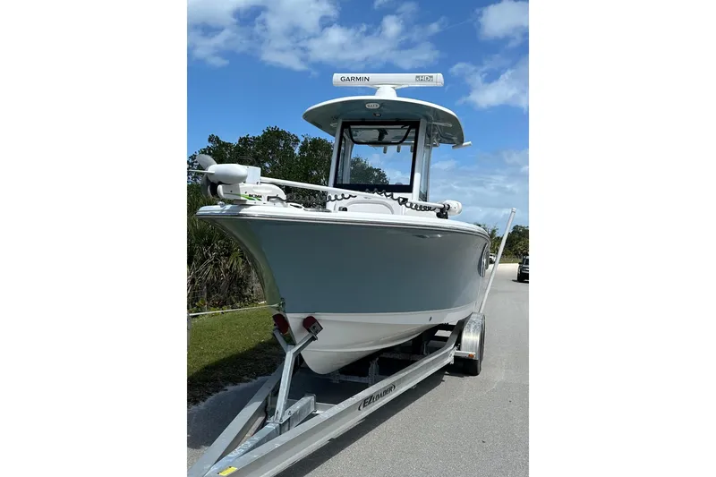 Slide: The Image of 2021 Sea Hunt Ultra 255 SE boat on trailer under blue sky. - 2