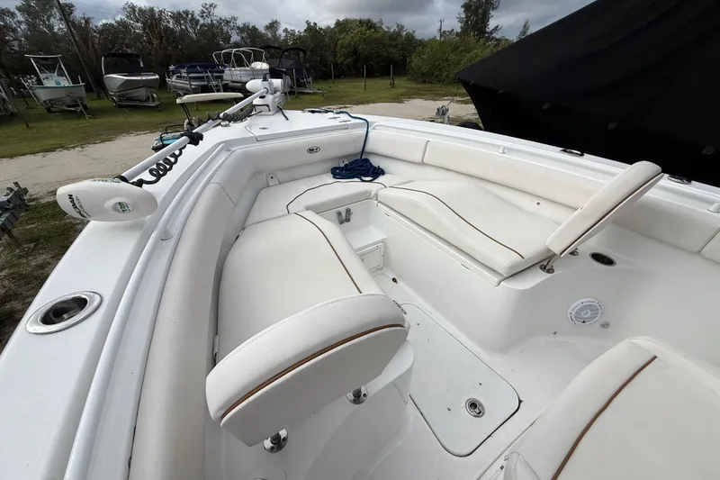 Slide: The Image of 2021 Sea Hunt Ultra 255 SE boat interior with white seating and fishing equipment. - 22