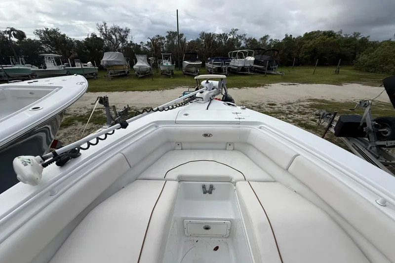 Slide: The Image of 2021 Sea Hunt Ultra 255 SE boat with white seating, parked outdoors. - 26