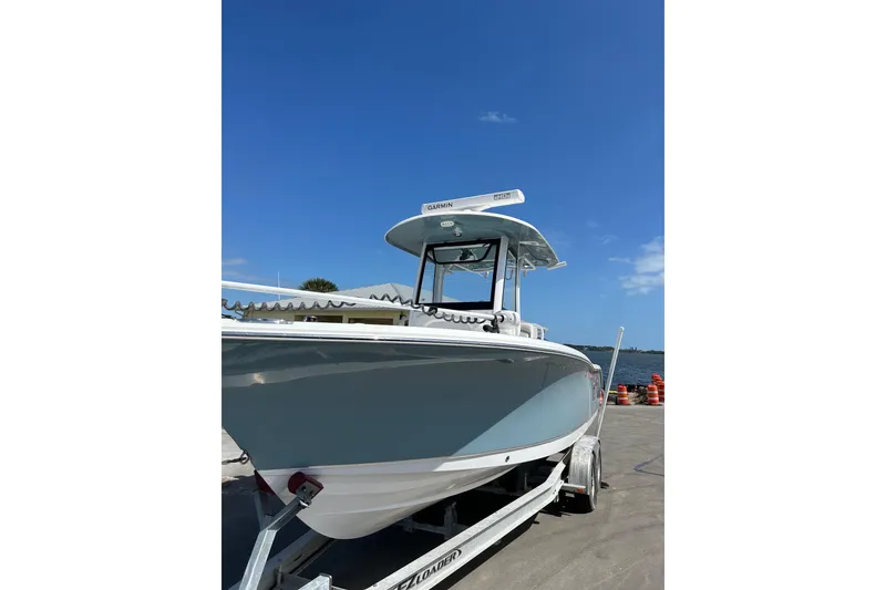 Slide: The Image of 2021 Sea Hunt Ultra 255 SE boat on trailer under clear blue sky. - 4