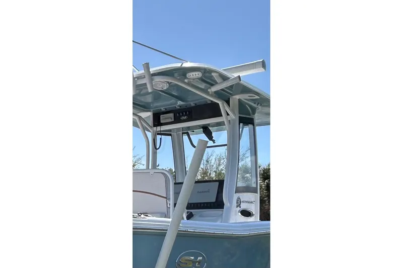 Slide: The Image of 2021 Sea Hunt Ultra 255 SE boat with T-top and rod holders under clear blue sky. - 5