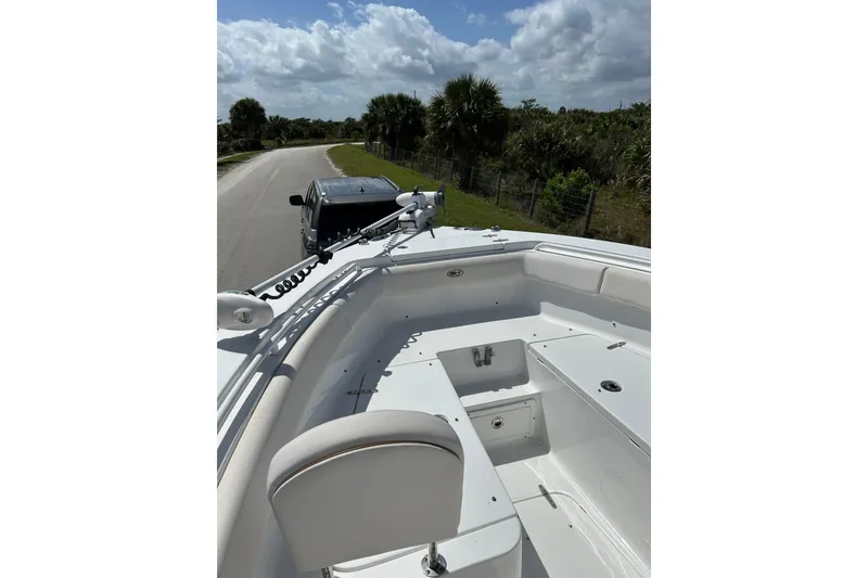 Slide: The Image of 2021 Sea Hunt Ultra 255 SE boat on trailer, parked on a scenic road. - 8