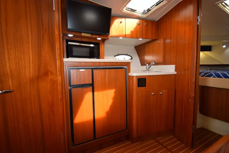 Slide: The Image of Interior of 2001 Tiara Yachts 3500 Open with kitchenette and wood paneling. - 37