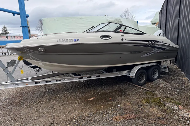The Image of 2022 Stingray 231 DC boat on trailer, parked outdoors. - 0