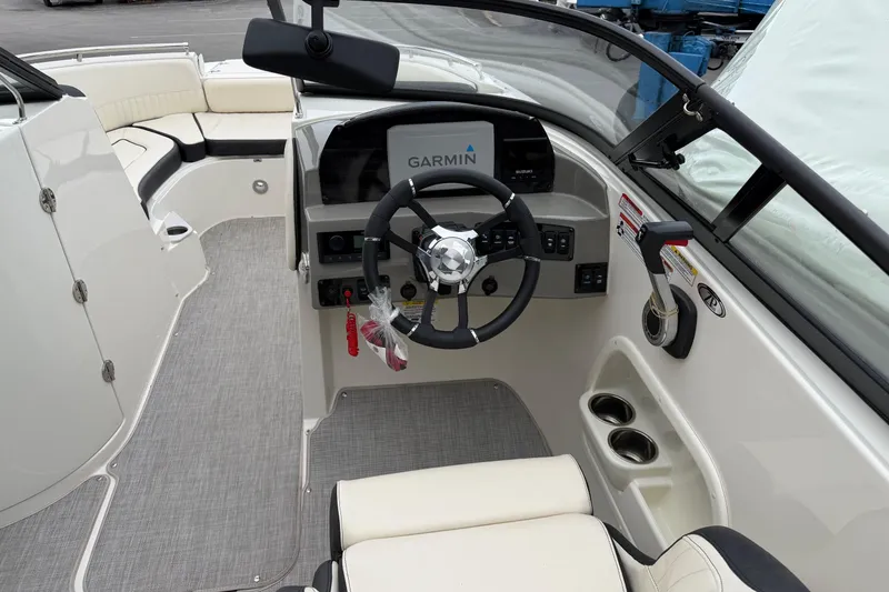 Slide: The Image of 2022 Stingray 231 DC boat cockpit with Garmin navigation system and comfortable seating. - 2