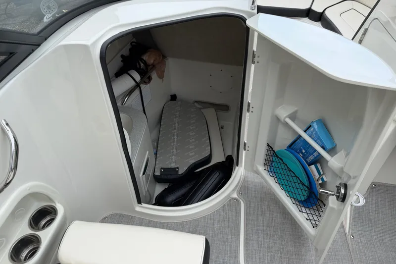 Slide: The Image of Storage compartment in 2022 Stingray 231 DC boat, featuring organized shelves and accessories. - 4