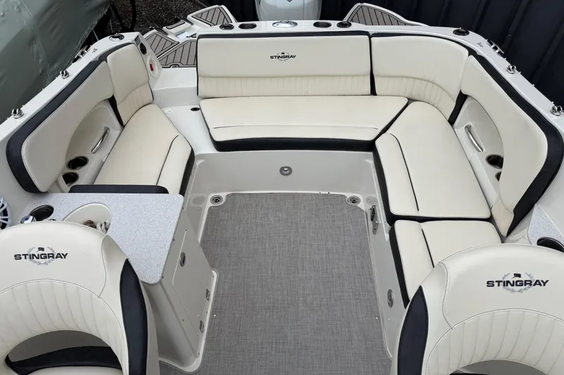 Slide: The Image of 2022 Stingray 231 DC boat interior with white seating and gray flooring. - 6