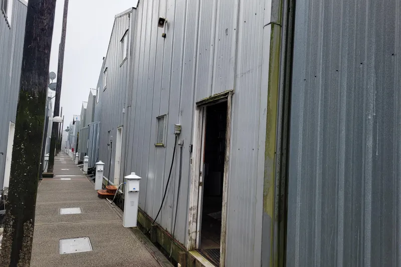 The Image of Row of custom boathouses with metal siding, 2015 design, along a narrow walkway. - 0