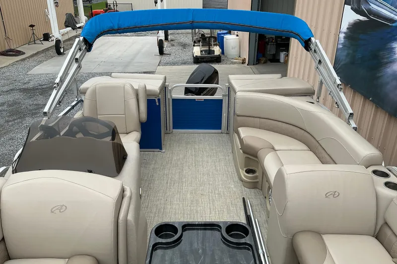 Slide: The Image of 2018 Avalon GS Cruise II 19' pontoon boat interior with beige seating and blue canopy. - 4