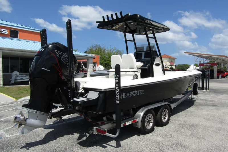 Slide: The Image of 2023 ShearWater 260 Carolina Flare boat on trailer, parked outdoors under blue sky. - 1