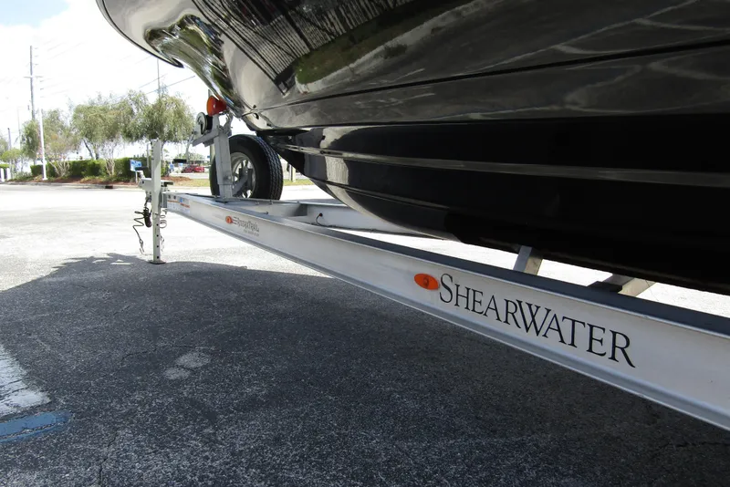 Slide: The Image of 2023 ShearWater 260 Carolina Flare boat on trailer, showcasing sleek hull design. - 10