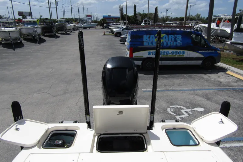 Slide: The Image of 2023 ShearWater 260 Carolina Flare boat in parking lot, rear view with open compartments. - 13