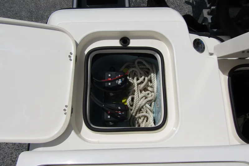 Slide: The Image of Storage compartment on 2023 ShearWater 260 Carolina Flare boat with ropes and battery switches. - 17