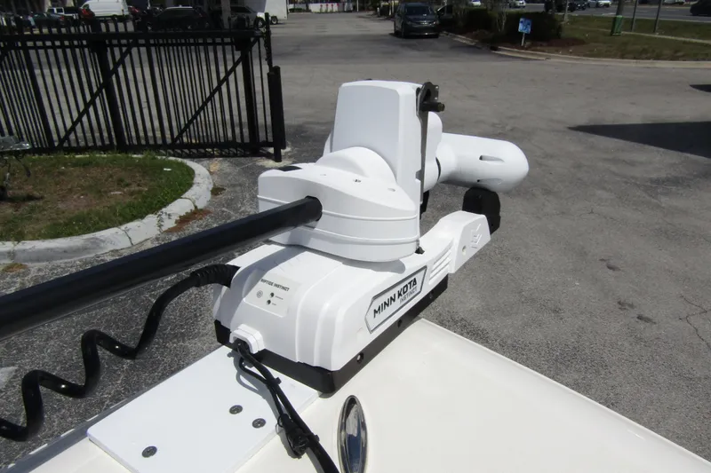 Slide: The Image of Minn Kota motor on 2023 ShearWater 260 Carolina Flare boat, parked near a gate. - 41