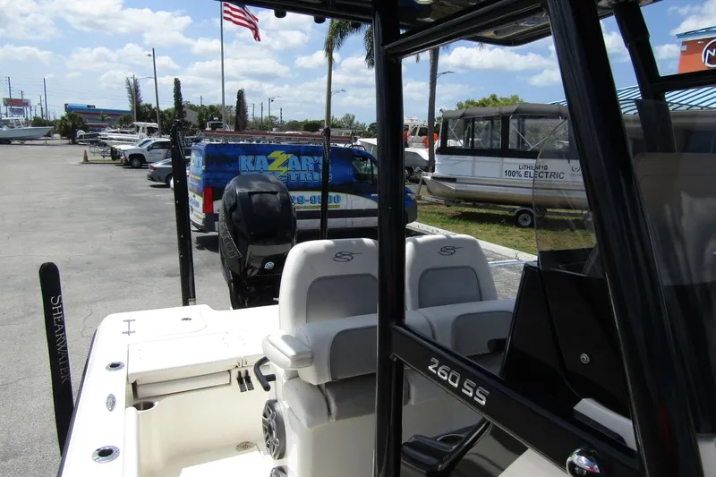 Slide: The Image of 2023 ShearWater 260 Carolina Flare boat at a dealership, showcasing seating and motor. - 45