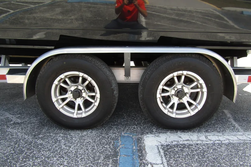 Slide: The Image of Trailer wheels of a 2023 ShearWater 260 Carolina Flare boat, parked on asphalt. - 9