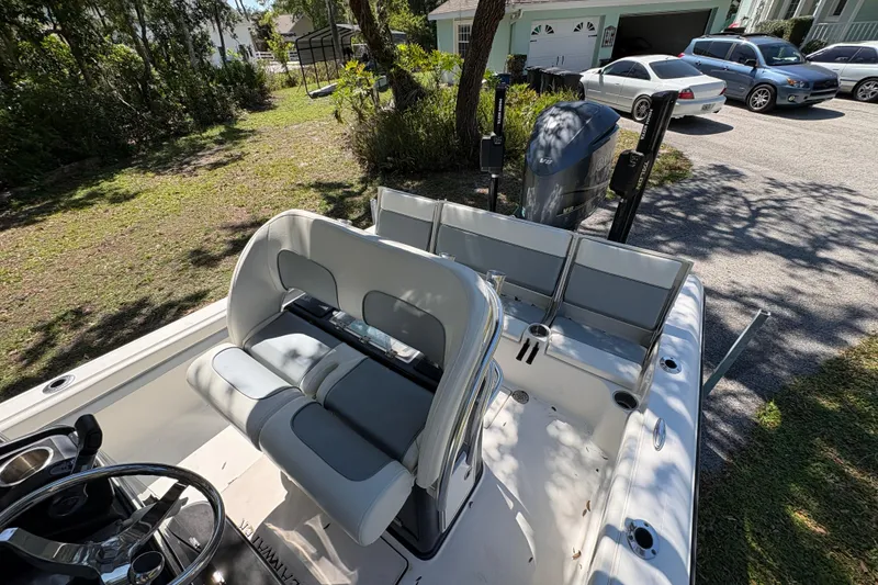 Slide: The Image of 2018 ShearWater 26 Carolina boat with seating and outboard motor in a residential driveway. - 11