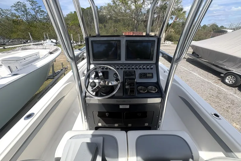 Slide: The Image of 2018 ShearWater 26 Carolina boat dashboard with dual screens and steering wheel. - 13