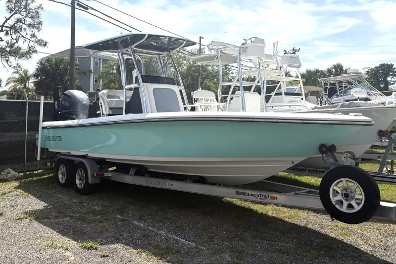 Slide: The Image of 2018 ShearWater 26 Carolina boat on trailer, parked outdoors. - 2