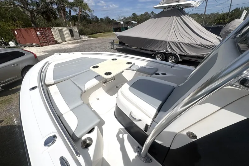 Slide: The Image of 2018 ShearWater 26 Carolina boat with spacious seating and table, parked outdoors. - 6