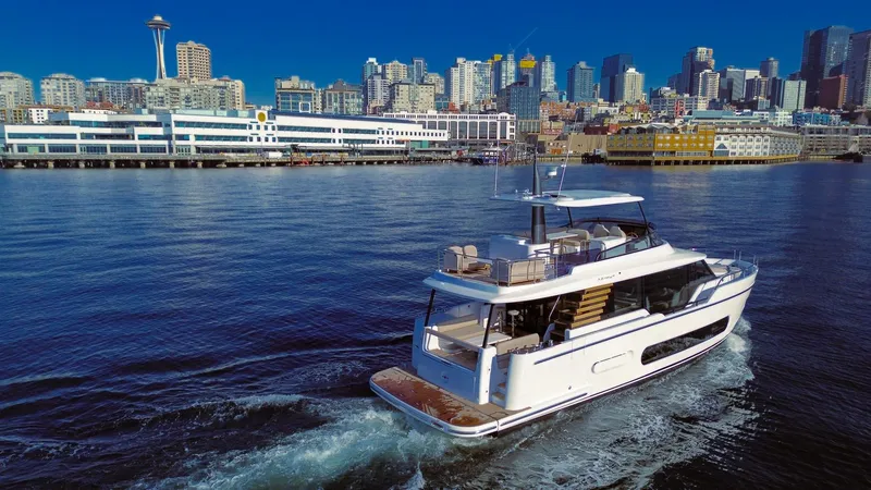 Slide: The Image of Azimut Magellano 60 yacht cruising near a city skyline, 2025 model. - 11