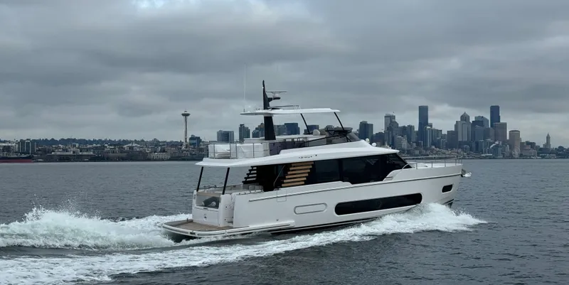 Slide: The Image of 2025 Azimut Magellano 60 yacht cruising near a city skyline under cloudy skies. - 12
