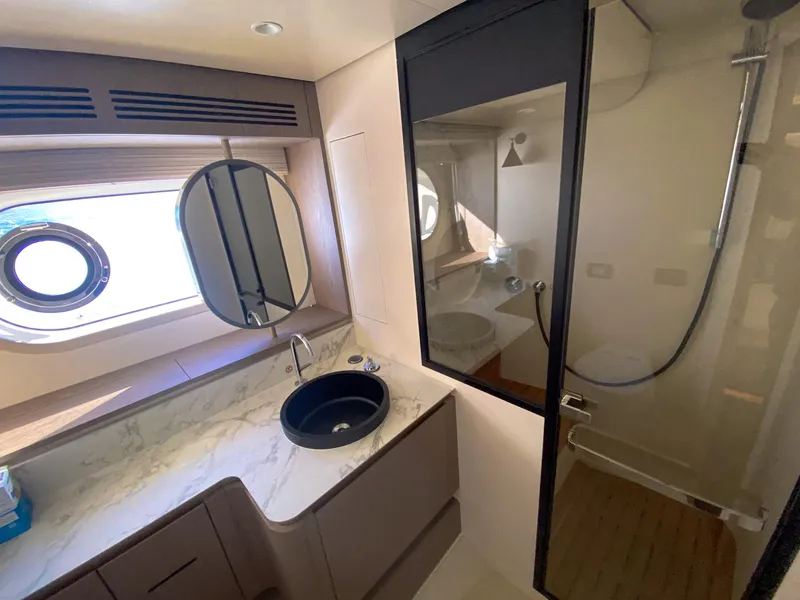 Slide: The Image of Luxurious bathroom in 2025 Azimut Magellano 60 yacht with modern fixtures and porthole window. - 14