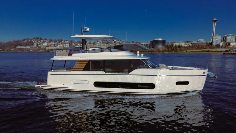 Slide: The Image of 2025 Azimut Magellano 60 yacht cruising on a calm waterway with cityscape background. - 2