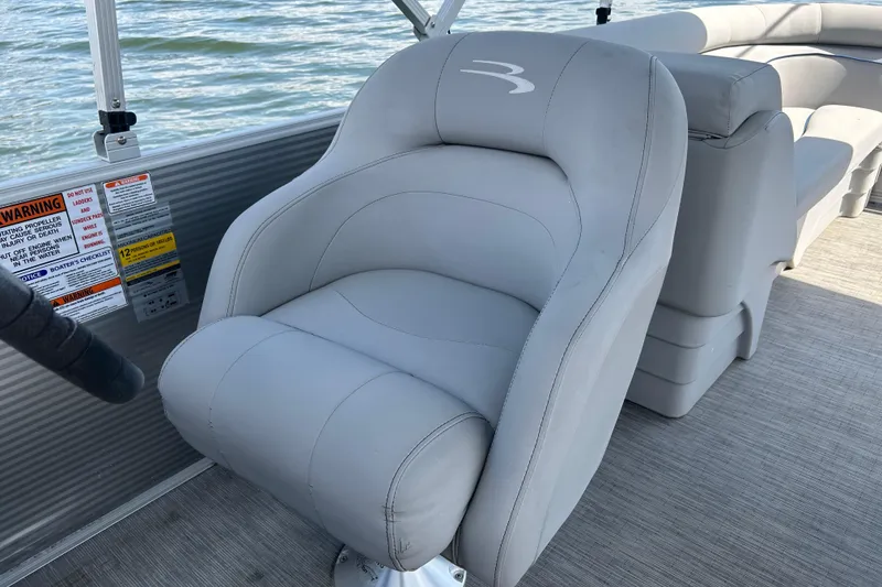 Slide: The Image of 2023 Bennington 22 SSR boat seat with gray upholstery on a sunny day. - 11