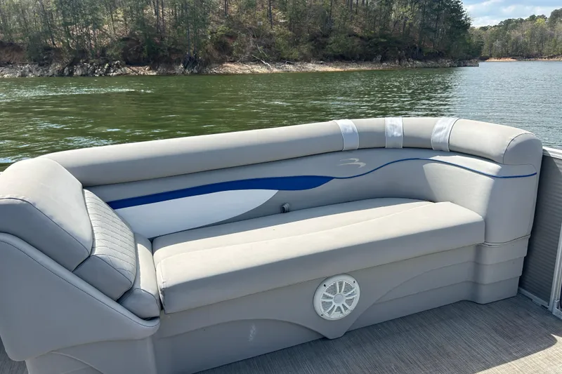 Slide: The Image of 2023 Bennington 22 SSR pontoon boat with comfortable seating on a scenic lake. - 15